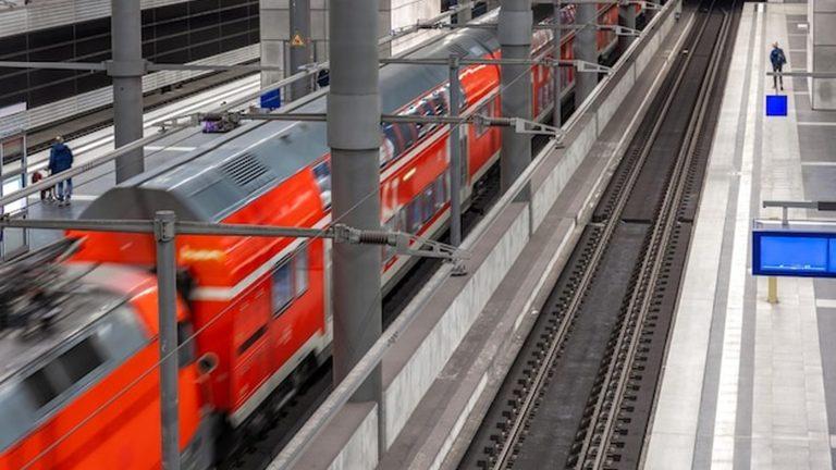 רכבת אדומה מודרנית מגיעה לתחנת רכבת - נסיעה ברכבת לזלצבורג